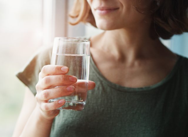 Close Up Woman Holding Glass Of Water, Belly Fat Loss Tips Concept For Women