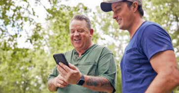 Two men reading phone apps