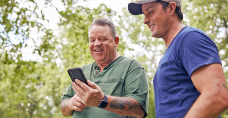 Two men reading phone apps