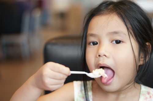 Pretty Young Asian Girl Eating Tuna And Corn Salad 