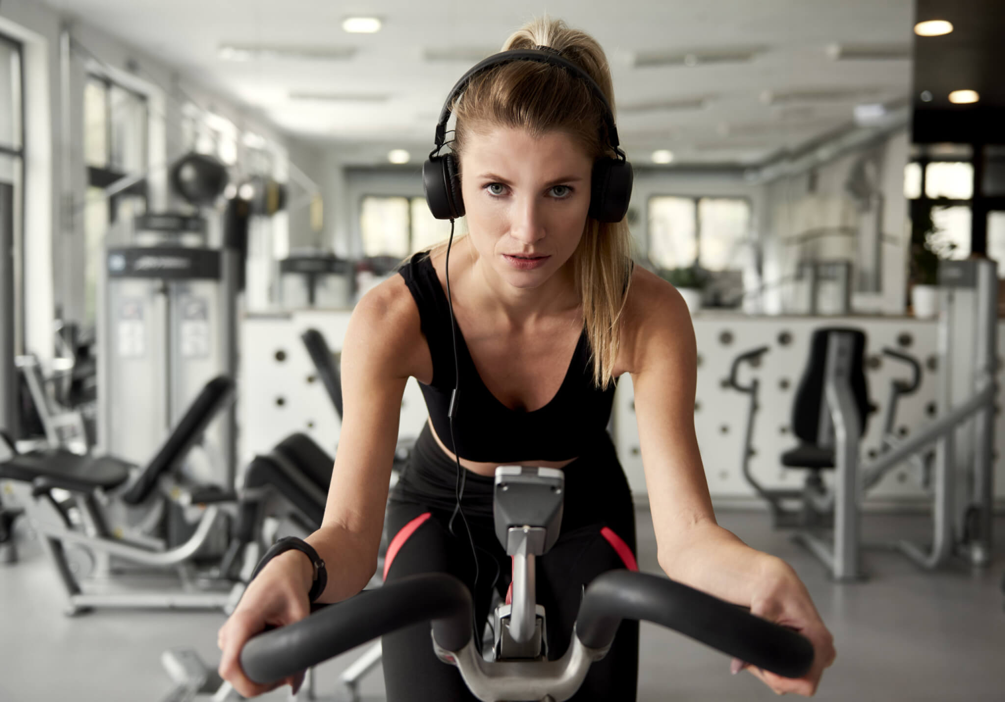 Woman working out on a bicycle while listening to music