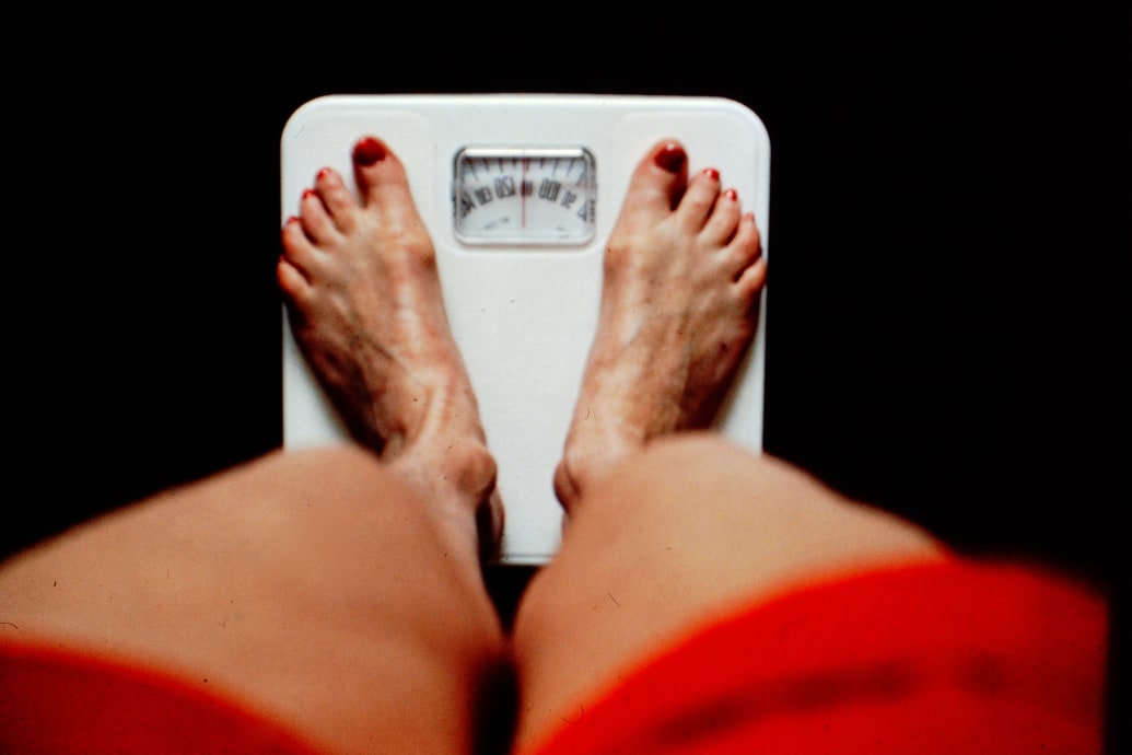 A woman standing on a scale.